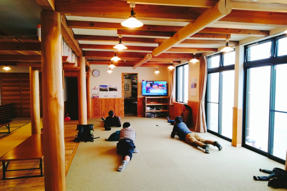 御嶽山の山小屋・ニノ池山荘の共有スペースで休むお客(大広間・食堂)の写真