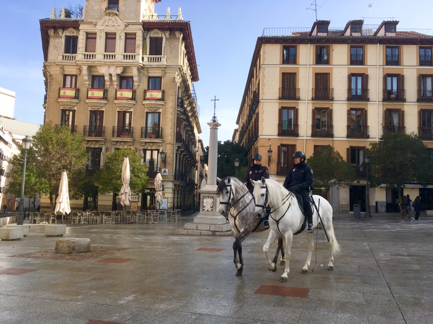 白馬でパトロールするスペインの警察官の写真